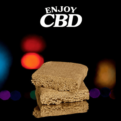 Três blocos castanhos empilhados com textura fibrosa e texto Enjoy CBD no fundo
