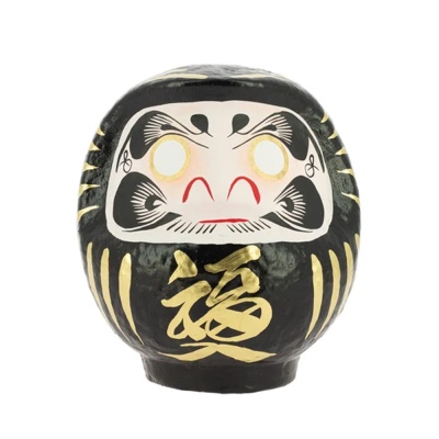 Figura Daruma preta com detalhes dourados e expressão facial pintada
