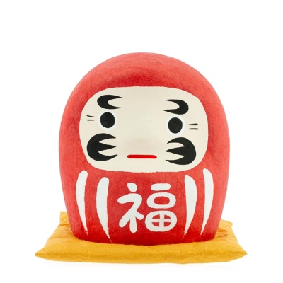 Boneco Daruma vermelho com rosto pintado e almofada amarela
