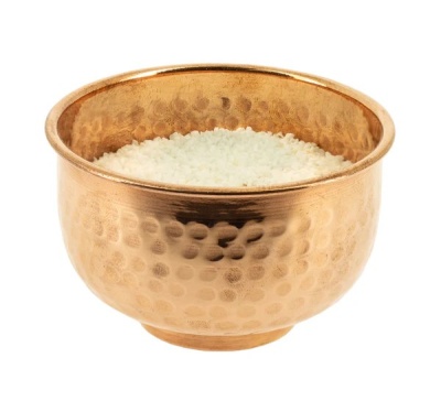 Taça de metal dourado com textura martelada cheia de arroz branco