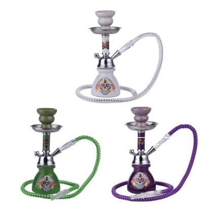 Três cachimbos de água decorados com caveiras coloridas em cores branco, verde e roxo