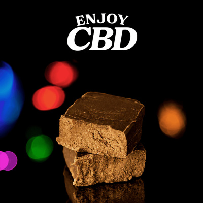 Cubos de chocolate castanho escuro com texto Enjoy CBD e fundo preto com luzes coloridas