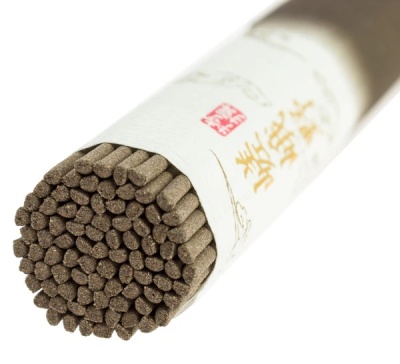 Pacote cilíndrico branco contendo varas finas castanhas e texto em caracteres asiáticos.