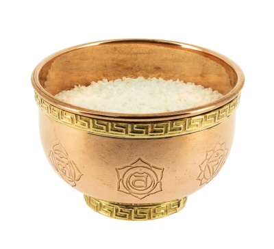 Tigela de metal dourado com sal grosso branco