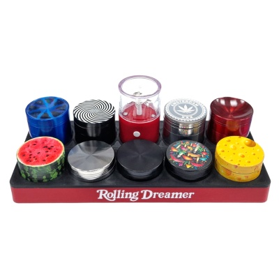Conjunto colorido de trituradores de ervas com padrões variados num suporte com texto Rolling Dreamer