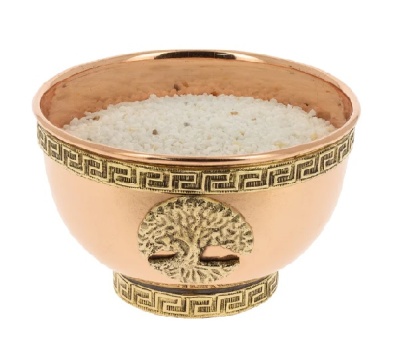 Taça cobre com decoração dourada e grãos brancos no interior