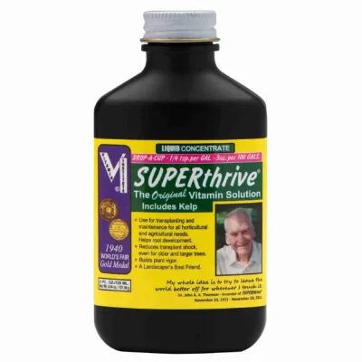 Frasco preto com solução vitamínica SUPERthrive e etiqueta amarela e verde