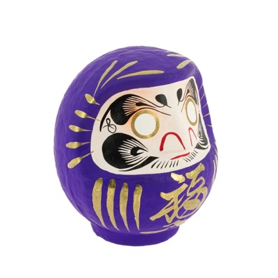 Daruma roxo com detalhes dourados e face pintada