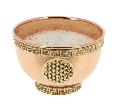 Taça de cobre com decoração dourada cheia de sal grosso branco