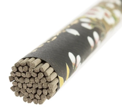 Incenso em pau com embalagem preta decorada com flores branca e verde