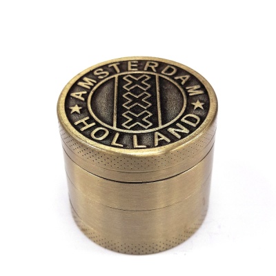 Triturador de metal cor de bronze com inscrições e design gravado no topo