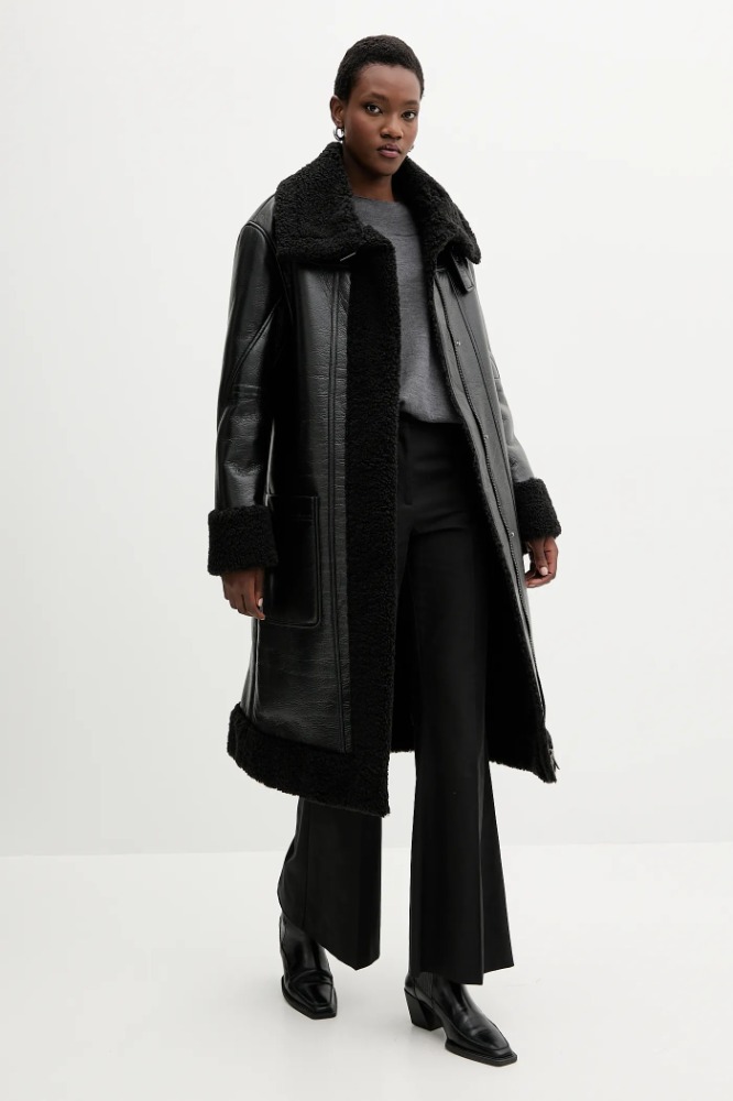 Shearling-effect leather coat Mulher a usar casaco preto comprido de couro com pêlo sintético e calças pretas
