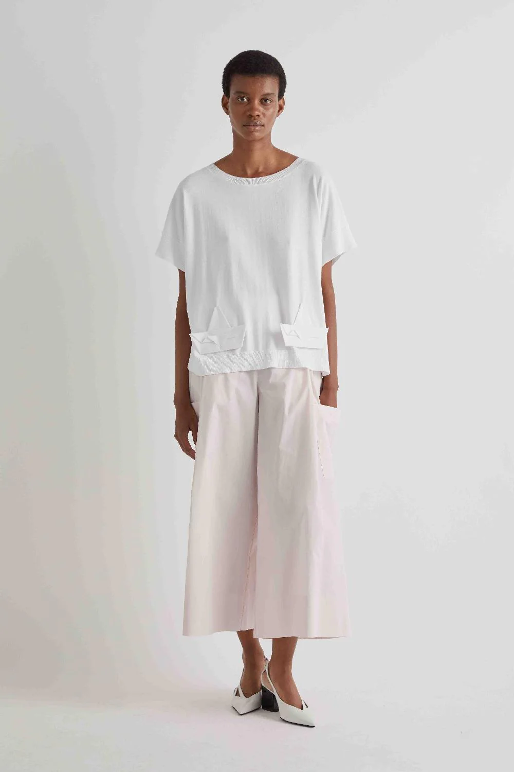 Cotton Palazzo Trousers Modelo a usar t-shirt branca de manga curta e calças largas creme com sapatos brancos de salto
