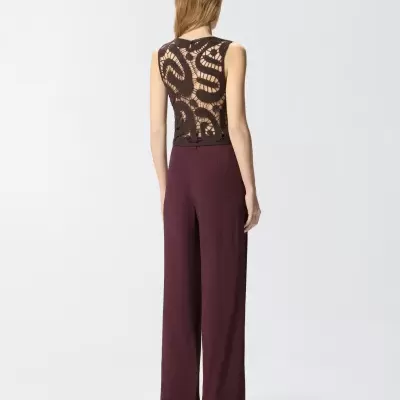 Conjunto feminino com top de renda preta e calças vinho largas visto de costas