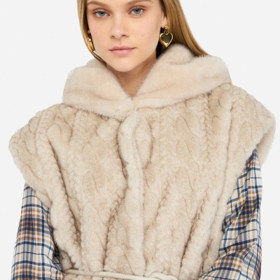 Mulher a vestir casaco de pêlo sintético bege e camisa xadrez