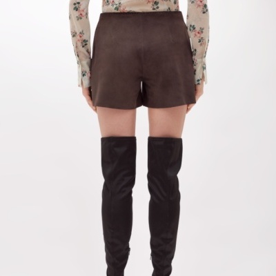 Shorts castanhos de tecido tipo camurça e botas pretas acima do joelho
