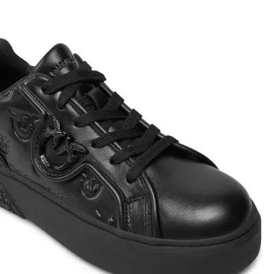 Tênis preto em pele com sola e atacadores pretos e detalhe metálico na lateral.