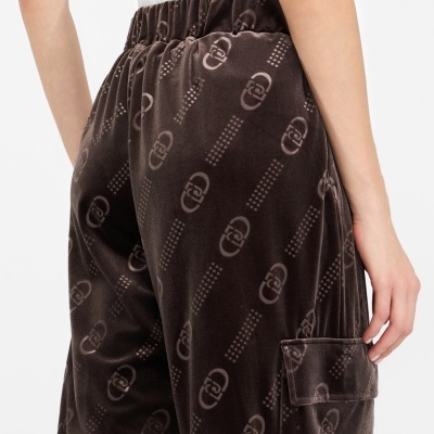 Calças de veludo castanhas com padrão de logótipos e bolso lateral