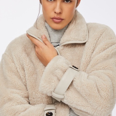 Casaco de pelo sintético bege claro com tiras em couro sintético