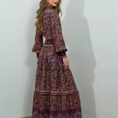 Vestido comprido floral roxo com mangas compridas e botas pretas.