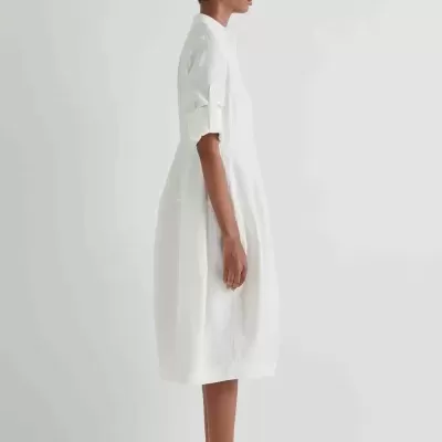 Vestido midi branco com mangas arregaçadas e sapatos pretos
