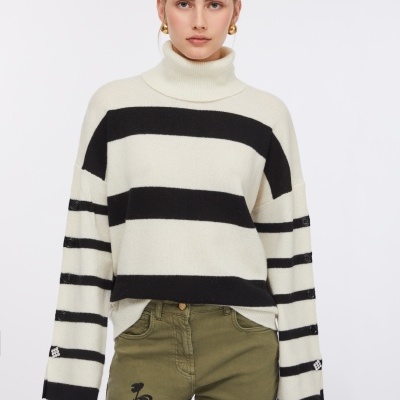 Camisola de gola alta às riscas em preto e branco com botões nas mangas e calças verdes bordadas