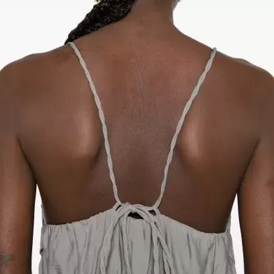 Parte traseira de vestido cinzento claro com alças torcidas finas e laço no centro das costas