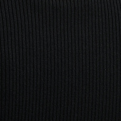 Pormenor de camisola preta de malha canelada com encaixe metálico dourado oval