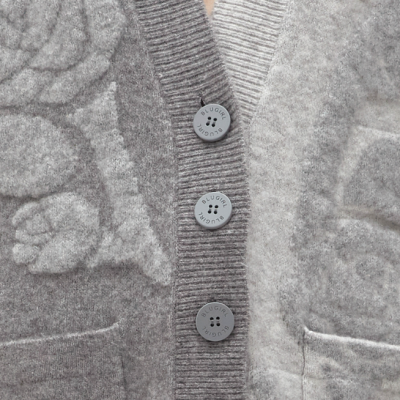 Cardigã cinzento com flores em relevo e botões com texto BLUGIRL