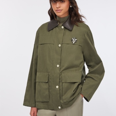 Casaco verde caqui com botões brancos e gola castanha em modelo feminino