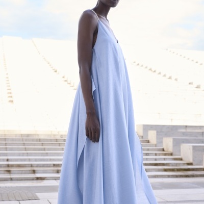 Vestido azul claro com alças finas e corte amplo numa modelo em ambiente exterior com escadas de pedra
