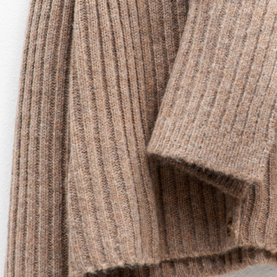 Casaco de malha castanho com nervuras verticais em fundo branco