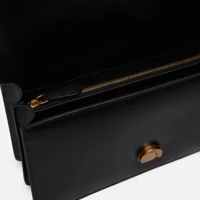 Carteira de couro preto com fecho dourado e interior com zíper.