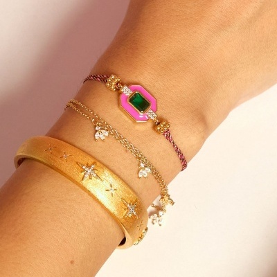 Pulseira com pedra verde e rosa, pulseira fina dourada com pedras e bracelete dourado largo com estrelas.