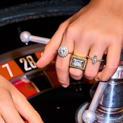 Mãos com anéis dourados a jogar roleta num casino