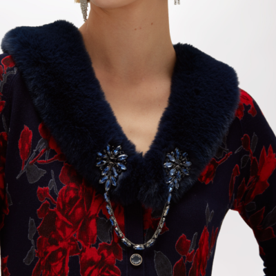 Cardigan azul escuro com padrão floral vermelho e gola em pelo azul com pedras e corrente