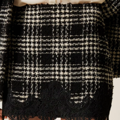 Saia curta xadrez preto e branco com renda preta na bainha