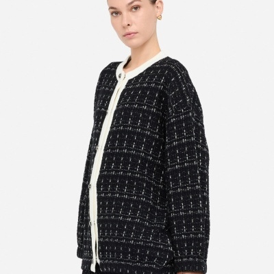 Conjunto feminino de casaco e saia preta com padrão xadrez branco