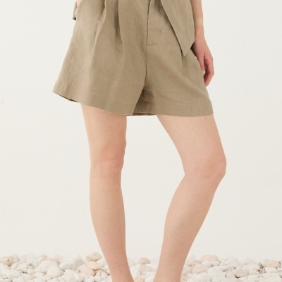 Calções e colete bege de linho com botões castanhos e sandálias de tiras azuis e brancas