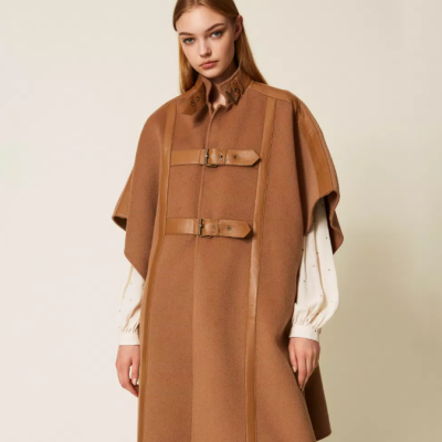 Capa castanha com fivelas e detalhes em couro, usada com blusa branca