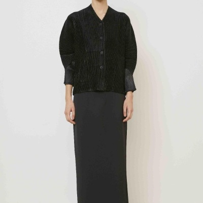 Conjunto feminino preto com blusa canelada e saia comprida em ambiente neutro