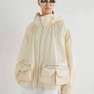 Casaco bege claro leve com bolsos grandes e fecho de correr