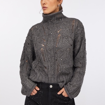 Camisola cinzenta de malha grossa com pedraria e calças pretas com pedraria