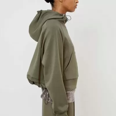 Pessoa de perfil com hoodie cropped verde oliva e manga comprida cinza aveludada por baixo