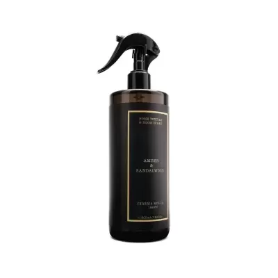 Frasco de spray escuro com rótulo preto e texto dourado