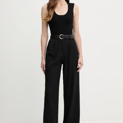 Mulher com roupa preta elegante, regata, calças largas e sapatos baixos