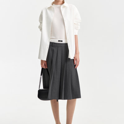 Mulher com camisa branca, saia cinza plissada, óculos de sol brancos e sapatos pretos