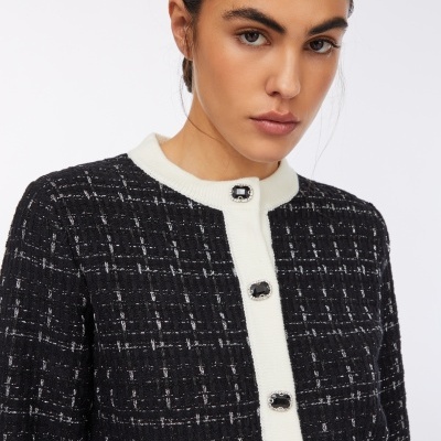 Casaco feminino preto com padrão de riscas e botões decorativos