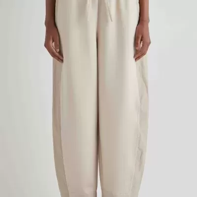 Calças largas beige claro com cordão e sapatilhas pretas