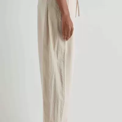 Calças bege claro e brancas com cintura elástica e sapatos pretos